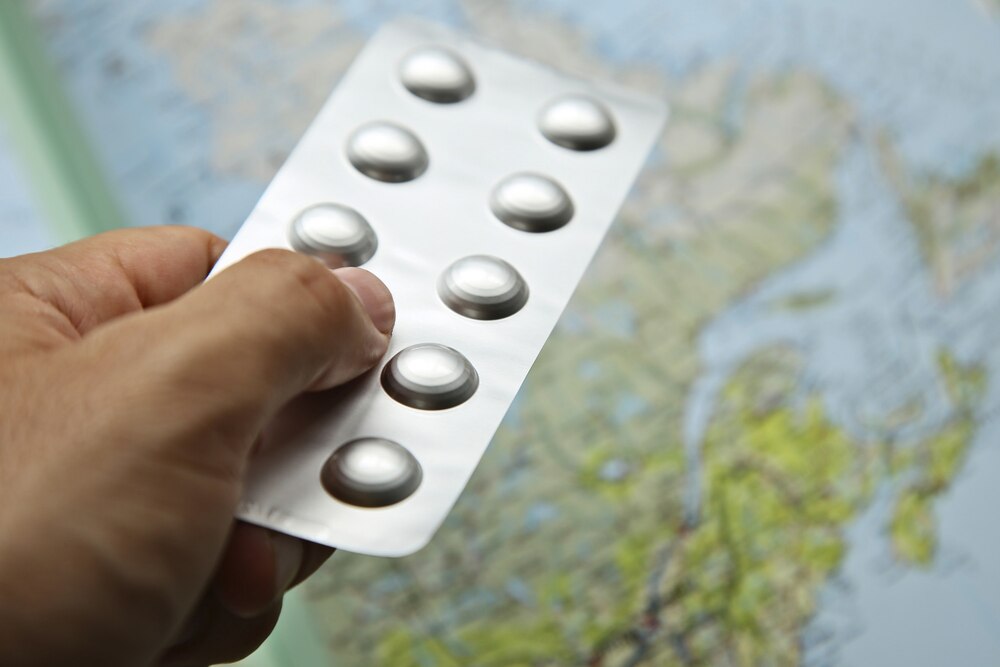 A pack of medical pills on a world map
