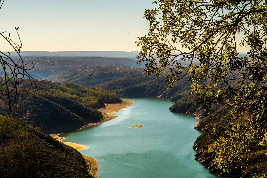 High angle shot of a big river surrounded by tree-covered hills